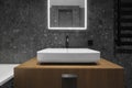 Modern minimalist bathroom dark interior design with dark stone tiles and wood furniture Royalty Free Stock Photo