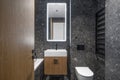 Modern minimalist bathroom dark interior design with dark stone tiles and wood furniture. Royalty Free Stock Photo