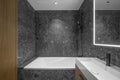 Modern minimalist bathroom dark interior design with dark stone tiles and wood furniture. Royalty Free Stock Photo