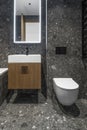 Modern minimalist bathroom dark interior design with dark stone tiles and wood furniture. Royalty Free Stock Photo