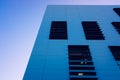 Modern minimalist building with smooth walls and square windows, with blue sky background Royalty Free Stock Photo