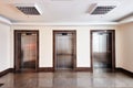 Modern minimalist business centre lobby interior with three closed steel lift doors Royalty Free Stock Photo