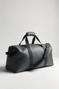 Modern, minimalist duffel holdall in a clean studio setting, emphasizing functionality. A modern, charcoal grey canvas duffel Royalty Free Stock Photo