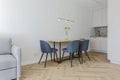 Modern minimalist kitchen and dining room interior design with wooden furniture, oak floor. blue chairs. Royalty Free Stock Photo