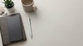 top view of smartphone on leather notebook with silver pen, wireless earbuds, and coffee on grey background Royalty Free Stock Photo