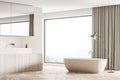 Modern minimalist panoramic bathroom with beige bathtub and floor lamp. Corner view Royalty Free Stock Photo
