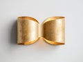 Modern minimalistic gold wall sconce with curved design casting soft light on light background for elegant interior decor Royalty Free Stock Photo