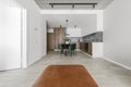 Modern minimalistic kitchen and dining room interior with wooden and white surfaces, green chairs Royalty Free Stock Photo