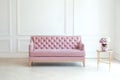 Modern minimalistic living room interior with a pink sofa and a table with a vase of bouquet of flowers against white wall. The s