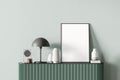 Modern mint color living room interior with light green chest of drawers, vases and lamp on it and blank canvas poster for ad Royalty Free Stock Photo