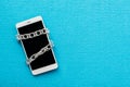 Modern mobile phone with chain locked isolate on blue background Royalty Free Stock Photo