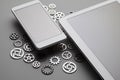 Modern mobile phone and tablet with blank screen and small gears on gray table Royalty Free Stock Photo