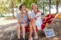 Modern mom and young daughter eating ice cream sitting on a deckchair in a water park on summer Royalty Free Stock Photo