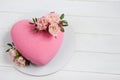 Modern  mousse cake .Heart shape  cake covered with pink chocolate velour and decoraited of pink roses.White wooden board.Concept Royalty Free Stock Photo