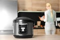 Modern multi cooker and blurred woman on background