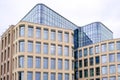 Modern multi-storey building with a glass facade. The evening sunset sky is reflected in the Windows of the facade Royalty Free Stock Photo