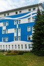 A modern multi-storey office building of unusual shape and coloring. The facade of the building is painted in blue and white Royalty Free Stock Photo