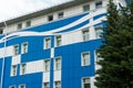 A modern multi-storey office building of unusual shape and coloring. The facade of the building is painted in blue and white Royalty Free Stock Photo