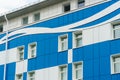 A modern multi-storey office building of unusual shape and coloring. The facade of the building is painted in blue and white Royalty Free Stock Photo