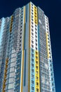 Modern multi-storey residential building against blue sky. Exterior wall of colorful high-rise house. View from below Royalty Free Stock Photo