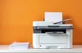 Modern multifunction printer machine on table. Device scans and prints documents. Photo of white printer and stack of sheets near Royalty Free Stock Photo
