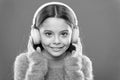Modern music is her life style and pleasure. Little modern girl wearing bluetooth headphones. Small child listening to