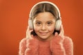 Modern music is her life style and pleasure. Little modern girl wearing bluetooth headphones. Small child listening to