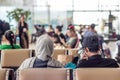 Modern muslim islamic asian couple sitting and waiting for flight departure at international airport terminal