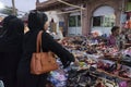 Modern Muslim women with hijab, cloth wrapping their head, neck and shoulder are buying colorful Rajsathani ladies shoes at famous