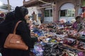 Modern Muslim women with hijab, cloth wrapping their head, neck and shoulder are buying colorful Rajsathani ladies shoes at famous