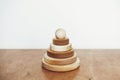 Modern natural wooden pyramid with rings on table on white wall background. Eco friendly plastic free toys for toddler. Stylish