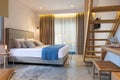 Modern nautical style interior of hotel apartment white bedroom with pine wood ladder, handmade wooden furniture, double bed Royalty Free Stock Photo