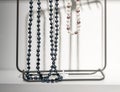 Modern necklaces hanged on a metallic frame on white