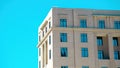 Modern neoclassical building with intense blue sky reflected in windows and negative space Royalty Free Stock Photo