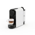 Modern nespresso coffee machine brewing a cup of espresso on a white surface Royalty Free Stock Photo