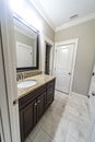 A modern new construction small guest bathroom with espresso cabinets, granite countertops, a tile floor and a mirror Royalty Free Stock Photo