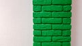 Modern new flat pink wall with a decorative brick column painted green. Abstract modern trendy texture background. Copy space Royalty Free Stock Photo