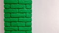Modern new flat pink wall with a decorative brick column painted green. Abstract modern trendy texture background. Copy space Royalty Free Stock Photo