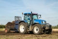 Modern New Holland tractor Tractor spreading manure on fields