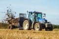 Modern New Holland tractor Tractor spreading manure on fields Royalty Free Stock Photo