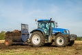 Modern New Holland tractor Tractor spreading manure on fields