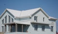 Modern house building with white tiled roof.