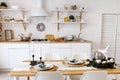 Modern new light interior of kitchen with white furniture and dining table Royalty Free Stock Photo