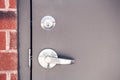 Modern new metallic grey shiny keyhole on door background. Front view of key lock and door handle Royalty Free Stock Photo