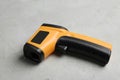 Modern non-contact infrared thermometer on grey stone background
