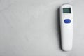 Modern non-contact infrared thermometer on grey stone background, top view. Space for text