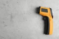 Modern non-contact infrared thermometer on grey stone background, top view. Space for text