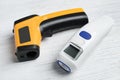 Modern non-contact infrared thermometers on wooden background