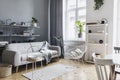 Modern nordic living room interior with design grey sofa, coffee table, plants, stylish accessories, decoration, carpet. Royalty Free Stock Photo