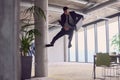 In the modern office, a businessman with a briefcase captivates everyone as he performs thrilling aerial acrobatics Royalty Free Stock Photo